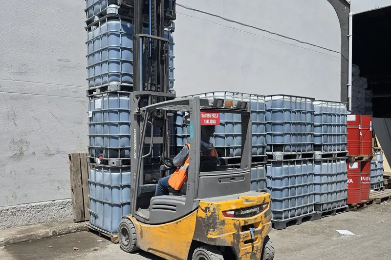 Forklift stacking IBC totes beside SINOVA Marine drums at the Mersin hub